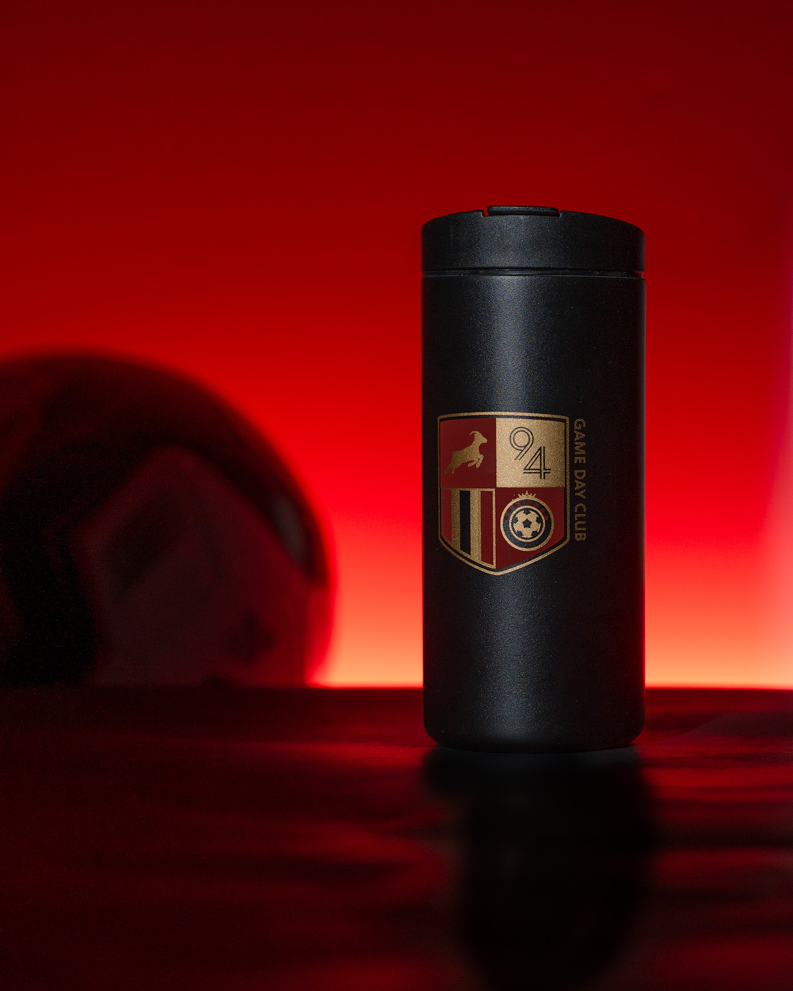 image of game day tumbler with soccer ball and red light background.